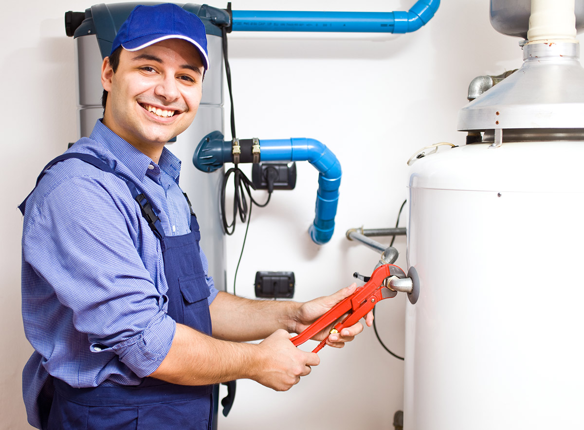 How to use video marketing: a smiling plumber facing the camera while fixing a hot water tank