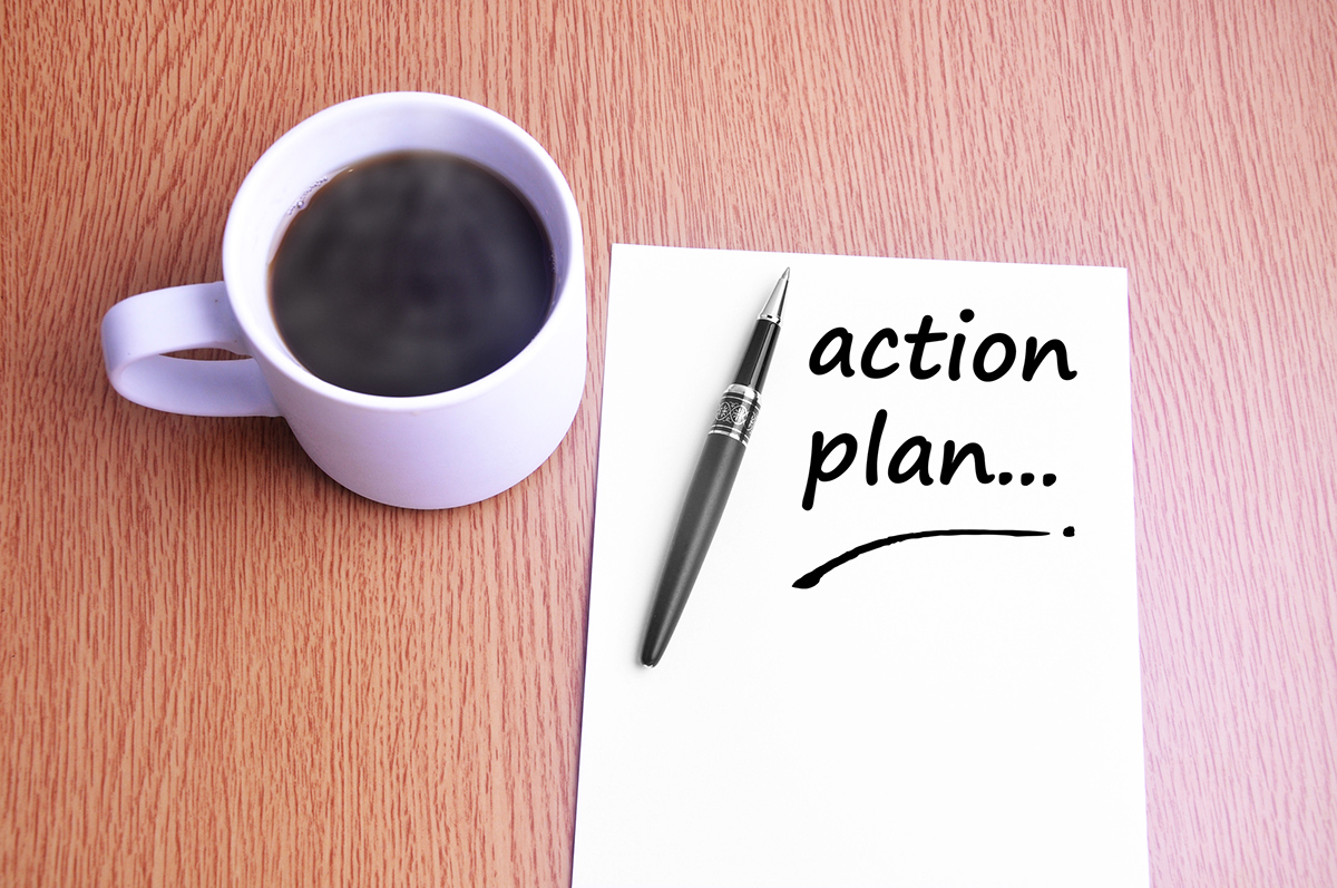 How to promote your self-storage business: a cup of black coffee beside a pen and paper with a note "action plan."