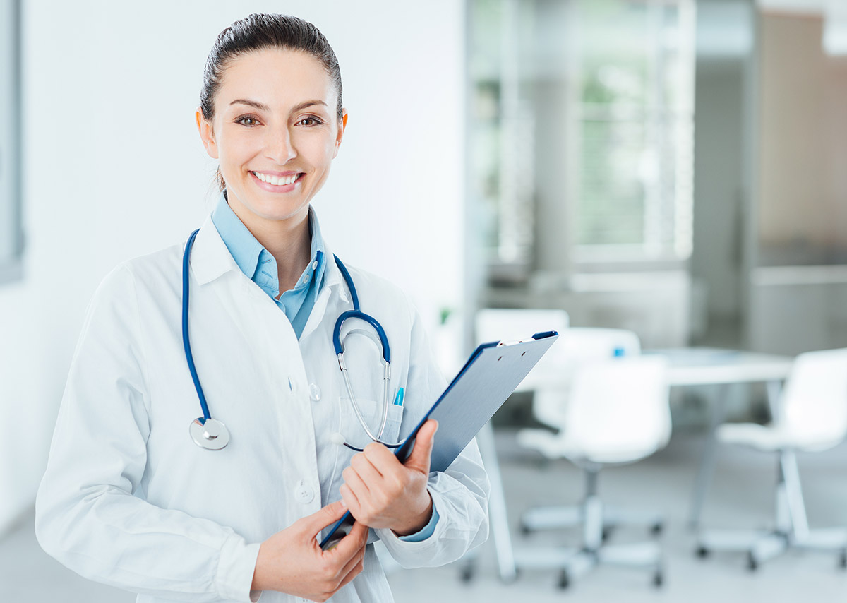SEO for medical practices: a photo of a smiling female doctor wearing a stethoscope and holding medical records